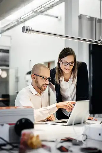 man and woman are in front of the computer